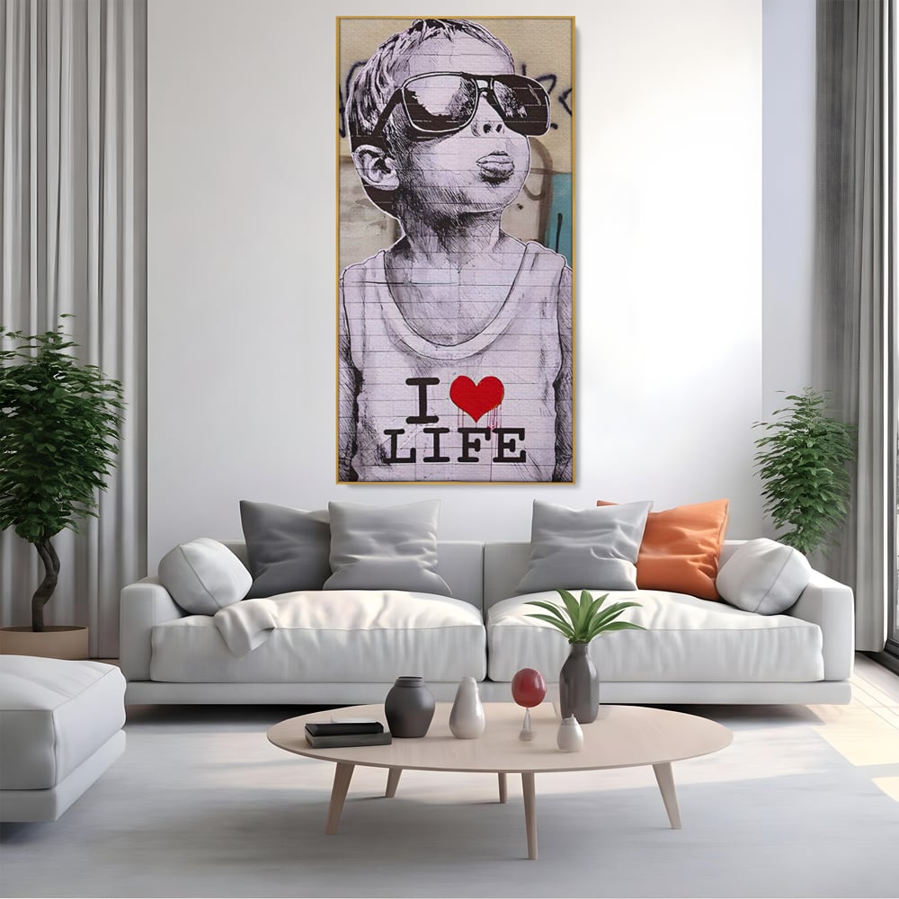 Tablou canvas cu tablou portret copil cu ochelari si inima, in rama de aluminiu auriu, pe perete intr-un living